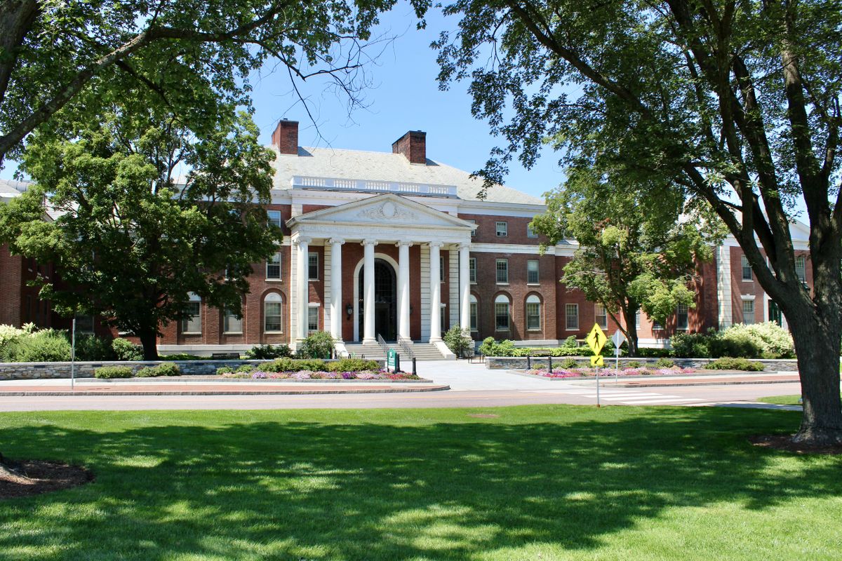 Brick educational building framed by mature trees and landscaped grounds